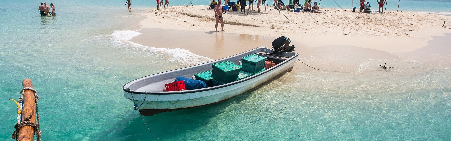 5 Days Zanzibar Ultimate Eco-Friendly Getaway. A breathtaking view of the Blue Lagoon in Zanzibar, featuring crystal-clear turquoise waters surrounded by lush greenery and white sandy shores.