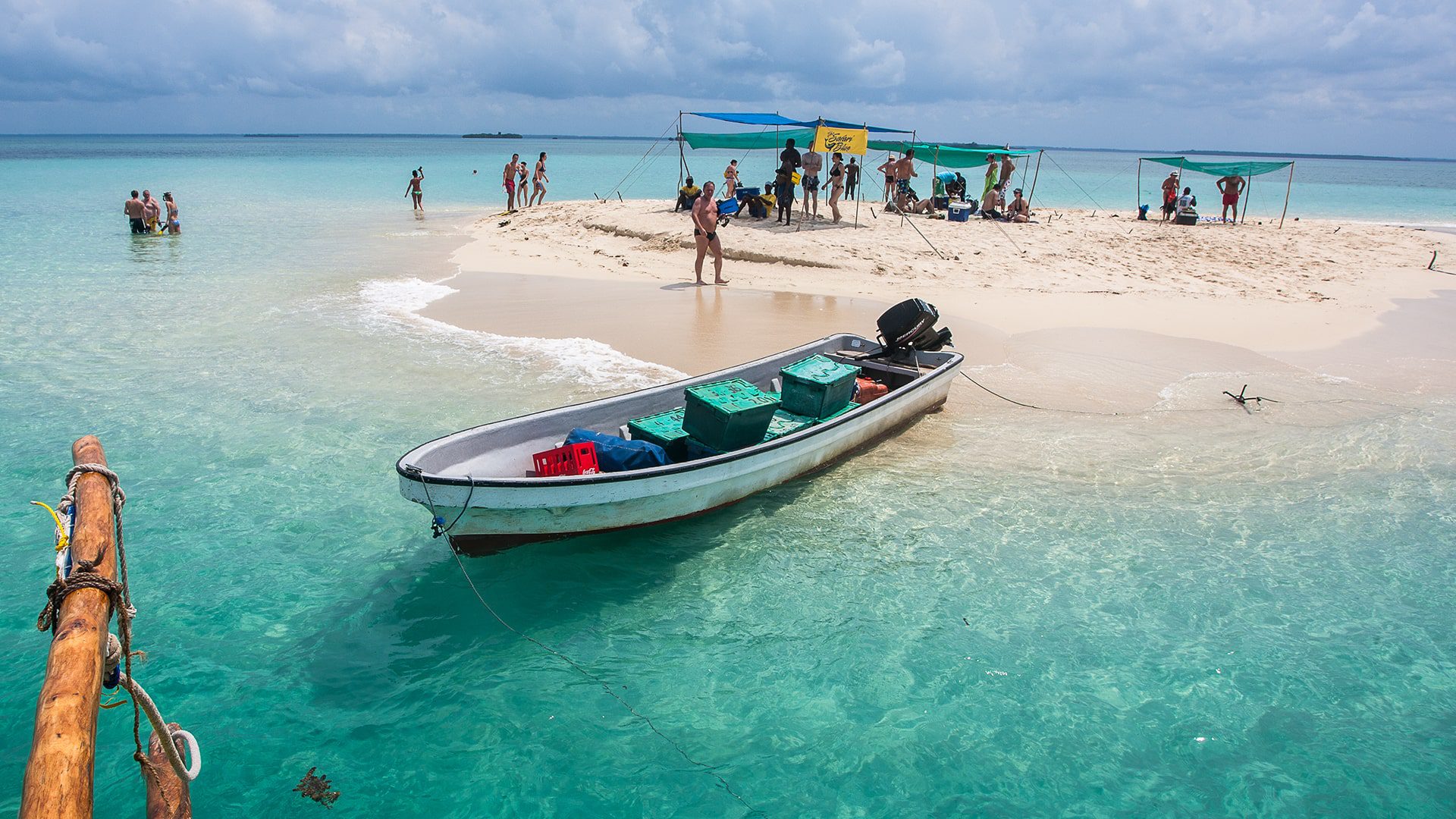 5 Days Zanzibar Ultimate Eco-Friendly Getaway. A breathtaking view of the Blue Lagoon in Zanzibar, featuring crystal-clear turquoise waters surrounded by lush greenery and white sandy shores.