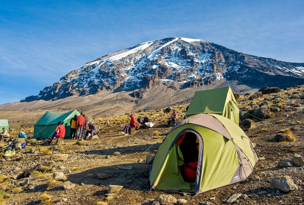 7 Days Explore Kilimanjaro Hike via Rongai Route winds its way up the slope of Mount Kilimanjaro, with a hint of mist and clouds in the distance.